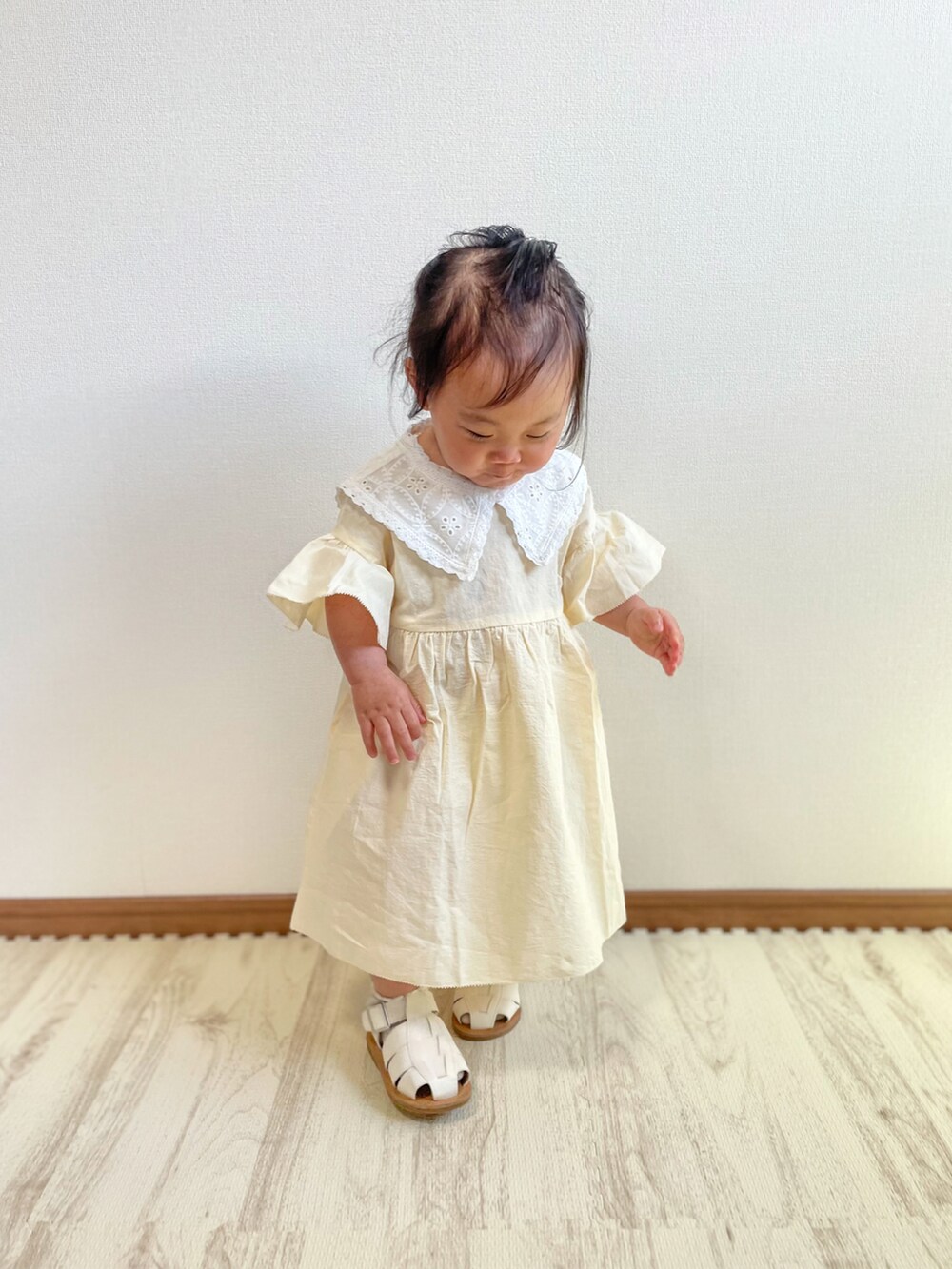 ホワイト系のワンピース、ホワイト系のサンダルを着用したキッズの春コーディネートの4枚目の写真