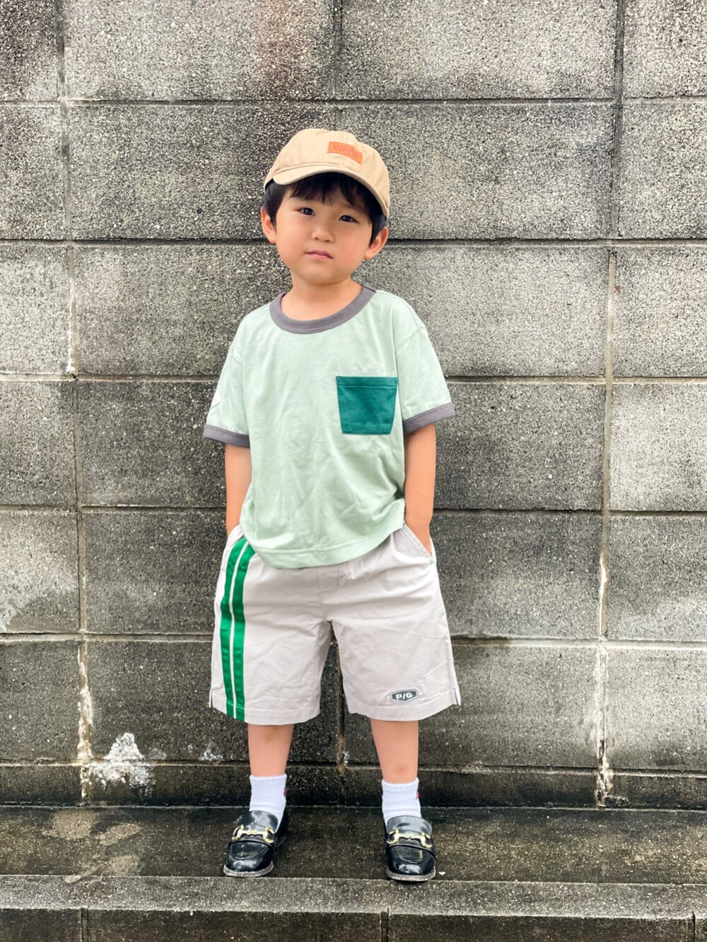 グリーン系のTシャツ/カットソー、グレー系のパンツ、ブラック系のローファーを着用したキッズの夏コーディネートの3枚目の写真