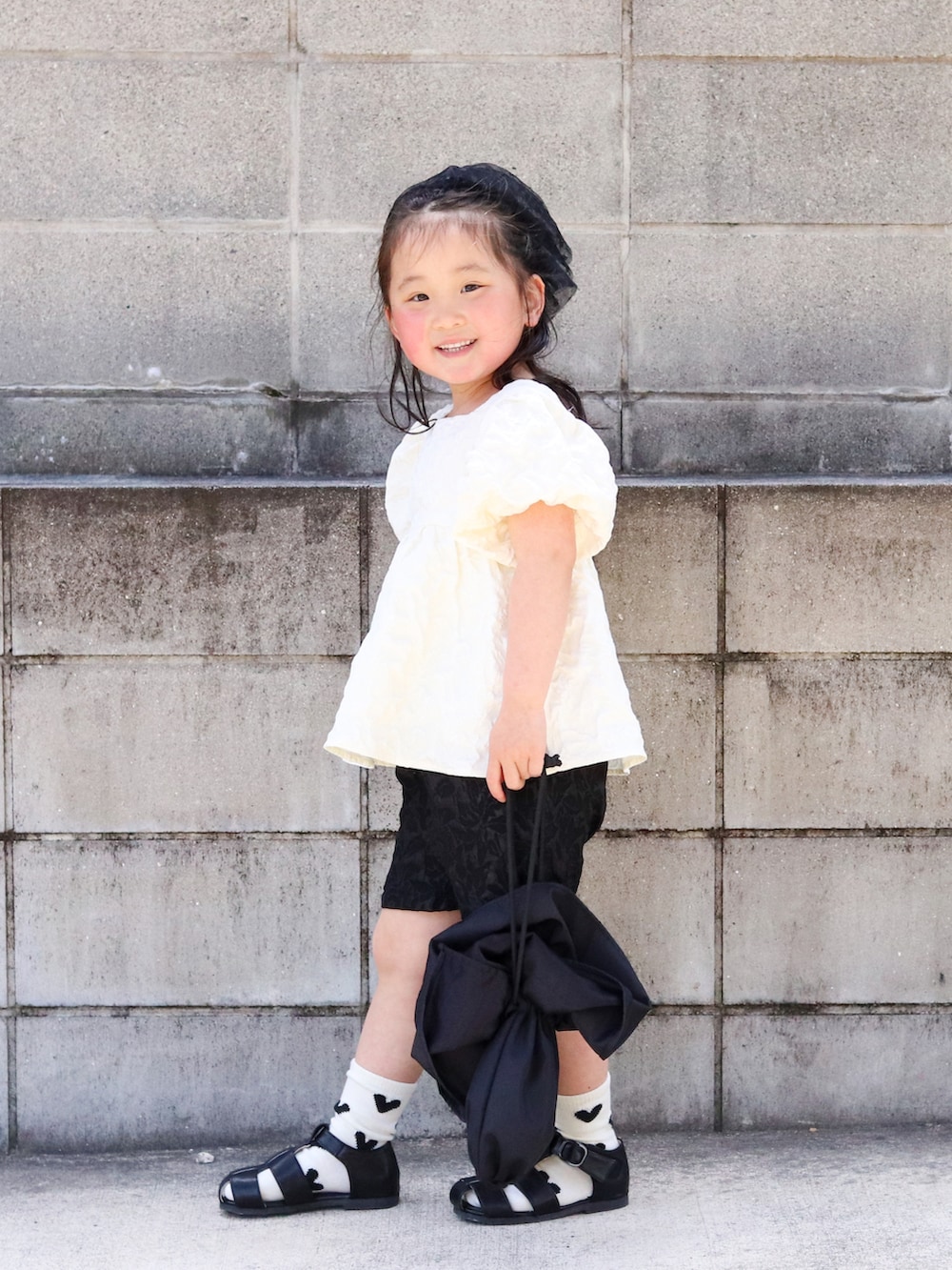 ホワイト系のシャツ/ブラウス、ブラック系のその他パンツ、ブラック系のサンダルを着用したキッズの春コーディネートの2枚目の写真