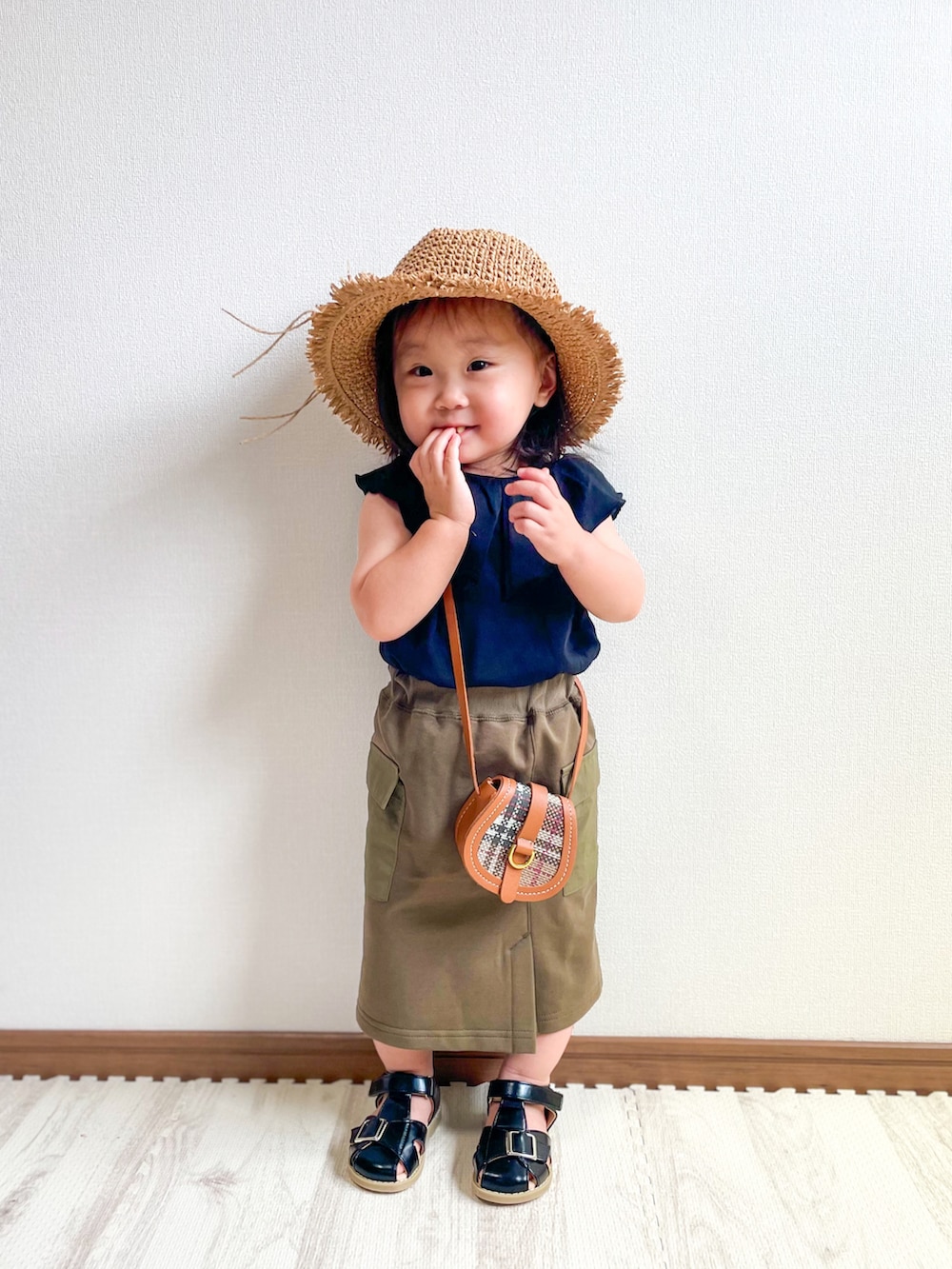 ブラック系のTシャツ/カットソー、グリーン系のスカート、ブラウン系のショルダーバッグを着用したキッズの夏コーディネートの3枚目の写真