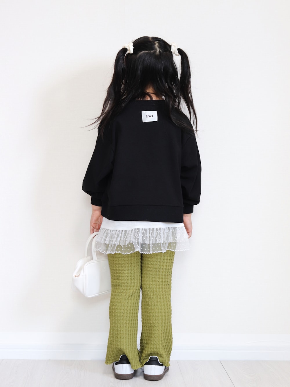 ホワイト系のショルダーバッグ、ホワイト系のスニーカー、ブラック系のTシャツ/カットソーを着用したキッズの秋コーディネートの4枚目の写真