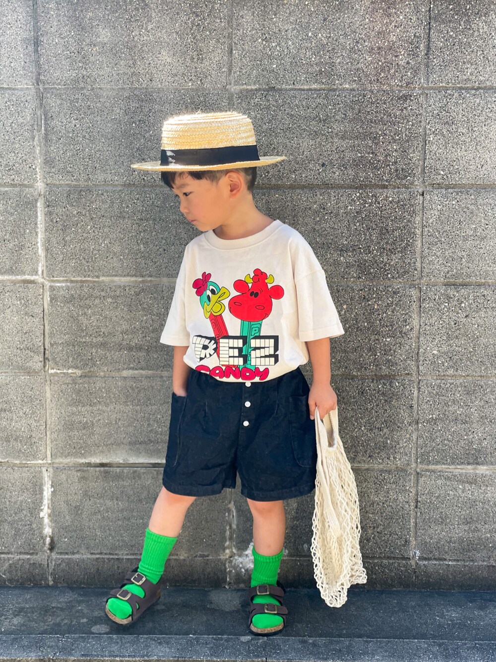 ホワイト系のTシャツ/カットソー、ブルー系のデニムパンツ、ブラウン系のサンダルを着用したキッズの夏コーディネートの3枚目の写真