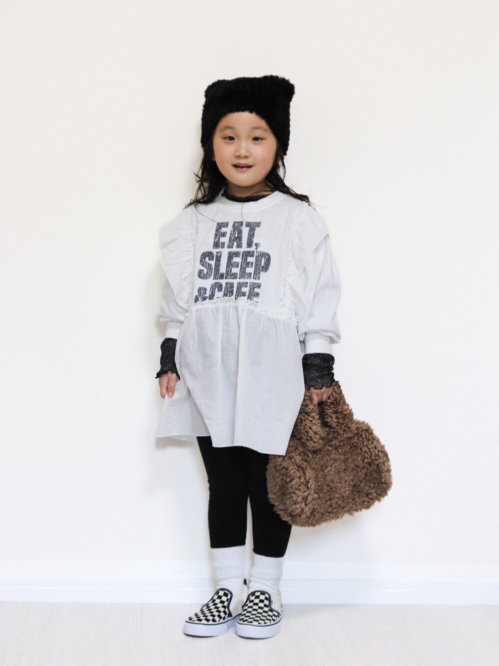 ホワイト系のワンピース、ブラック系のスニーカー、ブラック系のTシャツ/カットソーを着用したキッズの秋コーディネートの2枚目の写真