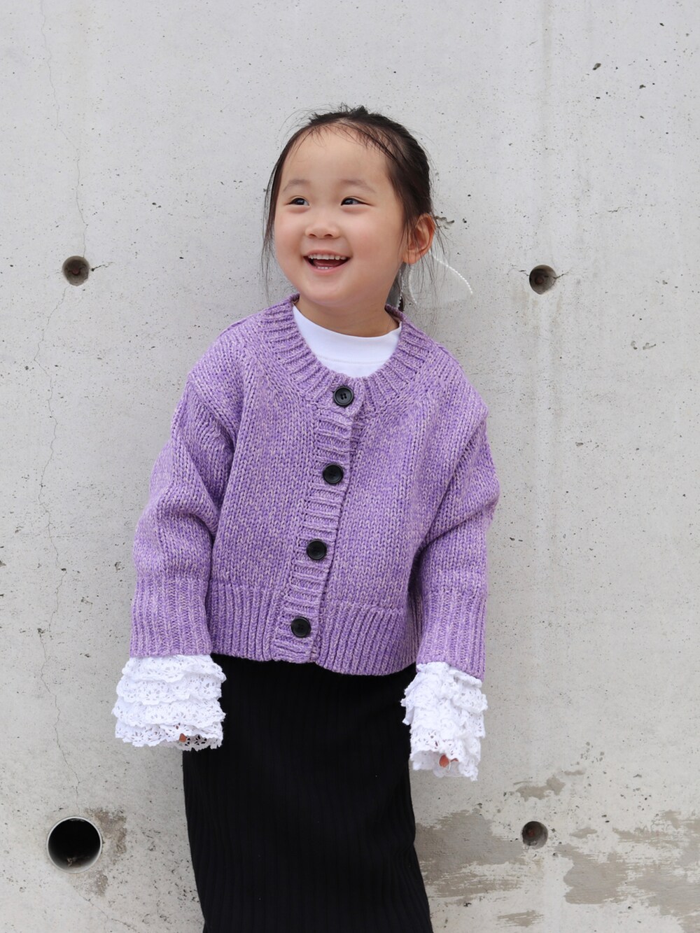 パープル系のカーディガン/ボレロ、ホワイト系のTシャツ/カットソー、ブラック系のスカートを着用したキッズの秋コーディネートの2枚目の写真