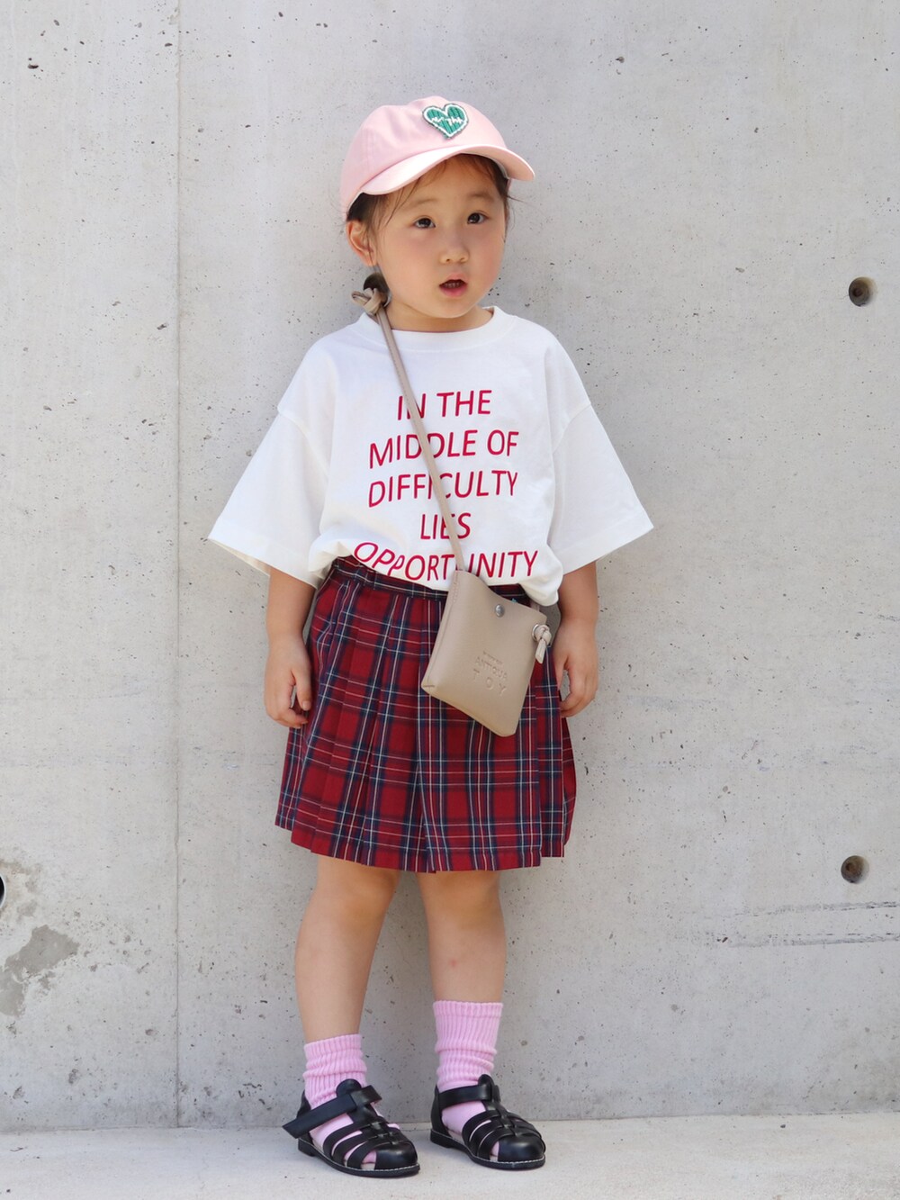 ホワイト系のTシャツ/カットソー、レッド系のスカート、ブラック系のサンダルを着用したキッズの夏コーディネートの2枚目の写真