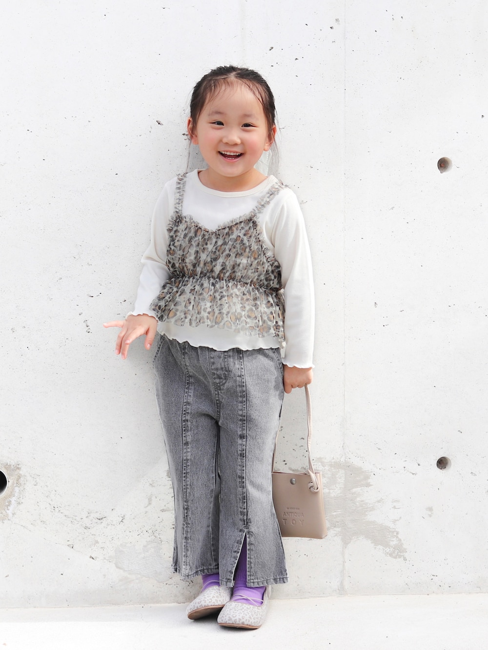 ホワイト系のTシャツ/カットソー、ブラック系のデニムパンツ、ベージュ系のバレエシューズを着用したキッズの冬コーディネートの2枚目の写真