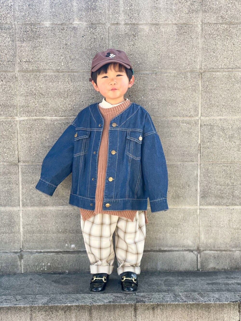 ブルー系のデニムジャケット、ブラウン系のベスト、ホワイト系のシャツ/ブラウスを着用したキッズの冬コーディネートの2枚目の写真