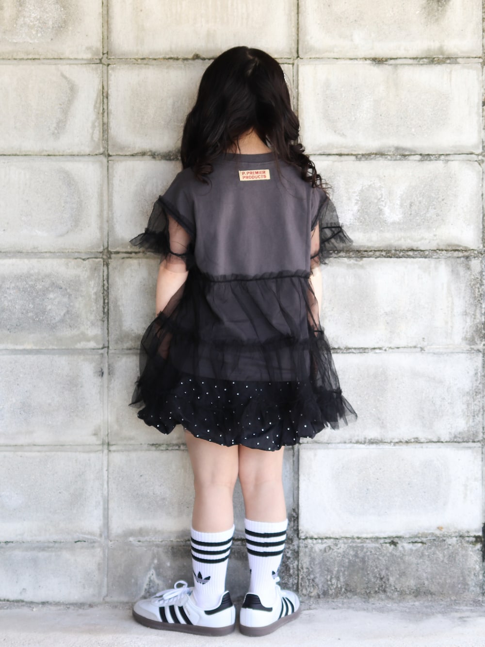 グレー系のTシャツ/カットソー、ブラック系のスカート、ホワイト系のスニーカーを着用したキッズの夏コーディネートの4枚目の写真