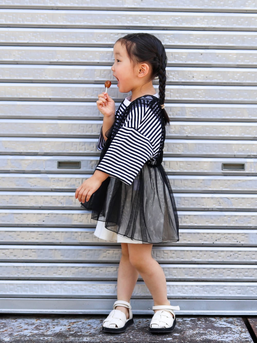 ブラック系のTシャツ/カットソー、ブラック系のチュニック、グレー系のスカートを着用したキッズの夏コーディネートの2枚目の写真