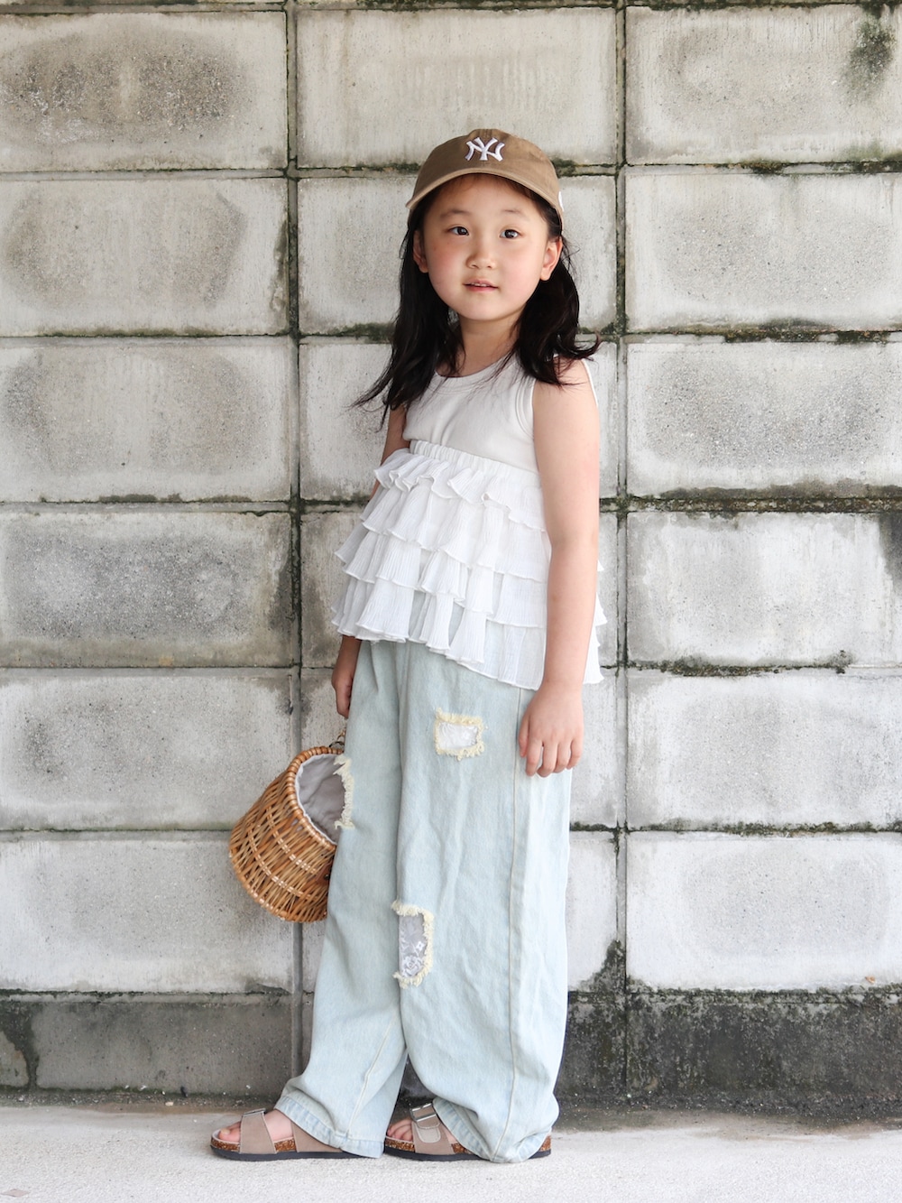 ブルー系のデニムパンツ、その他のかごバッグ、ベージュ系のサンダルを着用したキッズの夏コーディネートの2枚目の写真