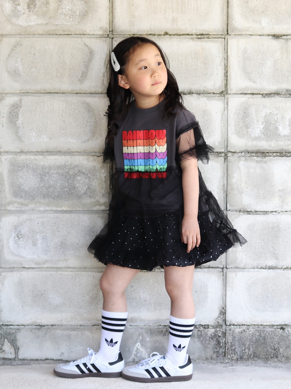 グレー系のTシャツ/カットソー、ブラック系のスカート、ホワイト系のスニーカーを着用したキッズの夏コーディネートの3枚目の写真