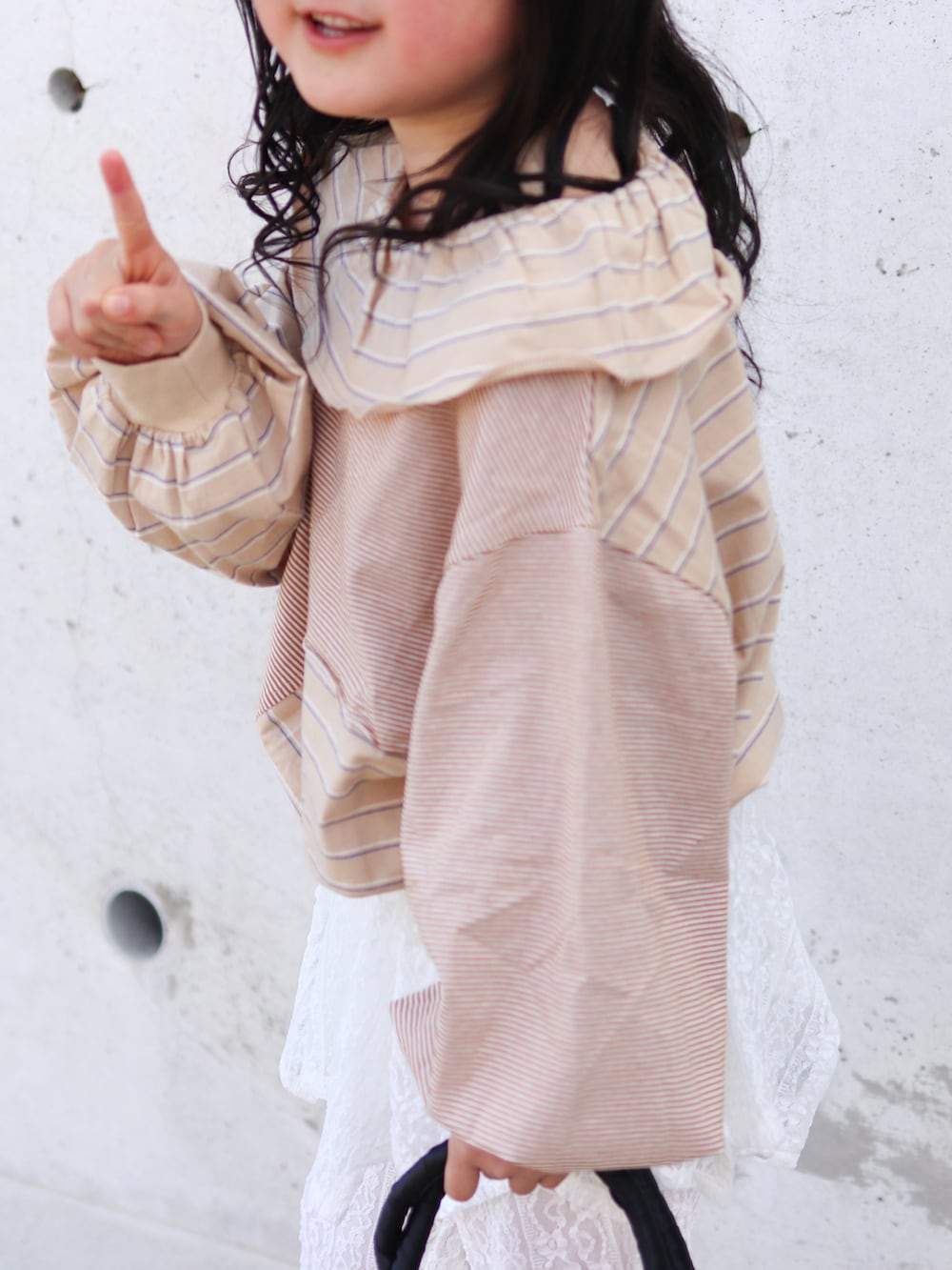 ホワイト系のその他パンツ、ベージュ系のTシャツ/カットソー、ブラック系のかごバッグを着用したキッズの春コーディネートの3枚目の写真