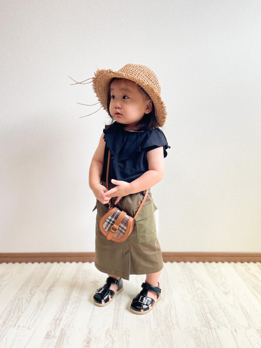 ブラック系のTシャツ/カットソー、グリーン系のスカート、ブラウン系のショルダーバッグを着用したキッズの夏コーディネートの2枚目の写真