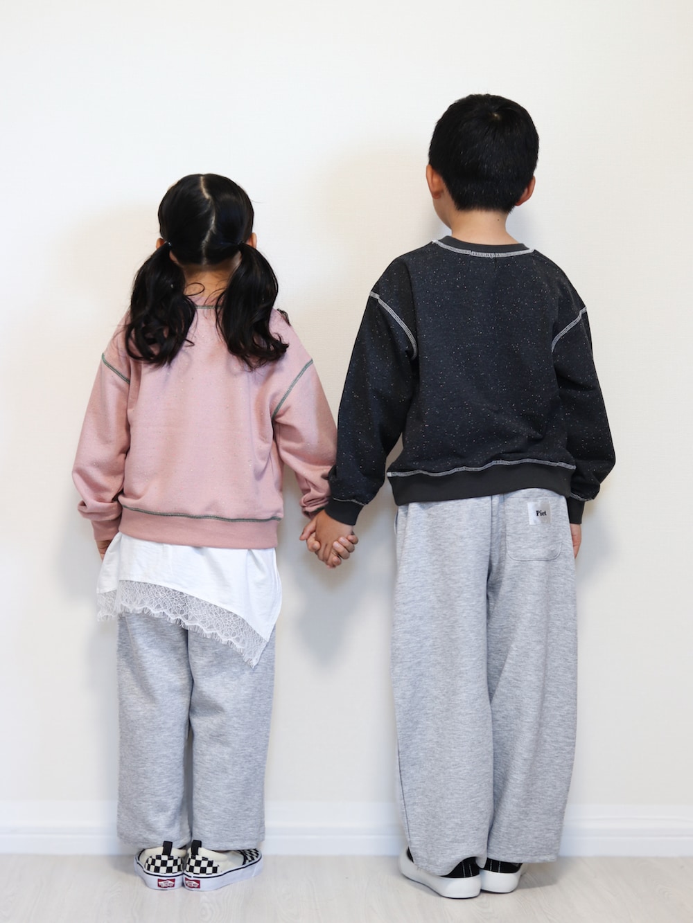 ピンク系のパーカー、ホワイト系のTシャツ/カットソー、グレー系のスウェットパンツを着用したキッズの秋コーディネートの3枚目の写真