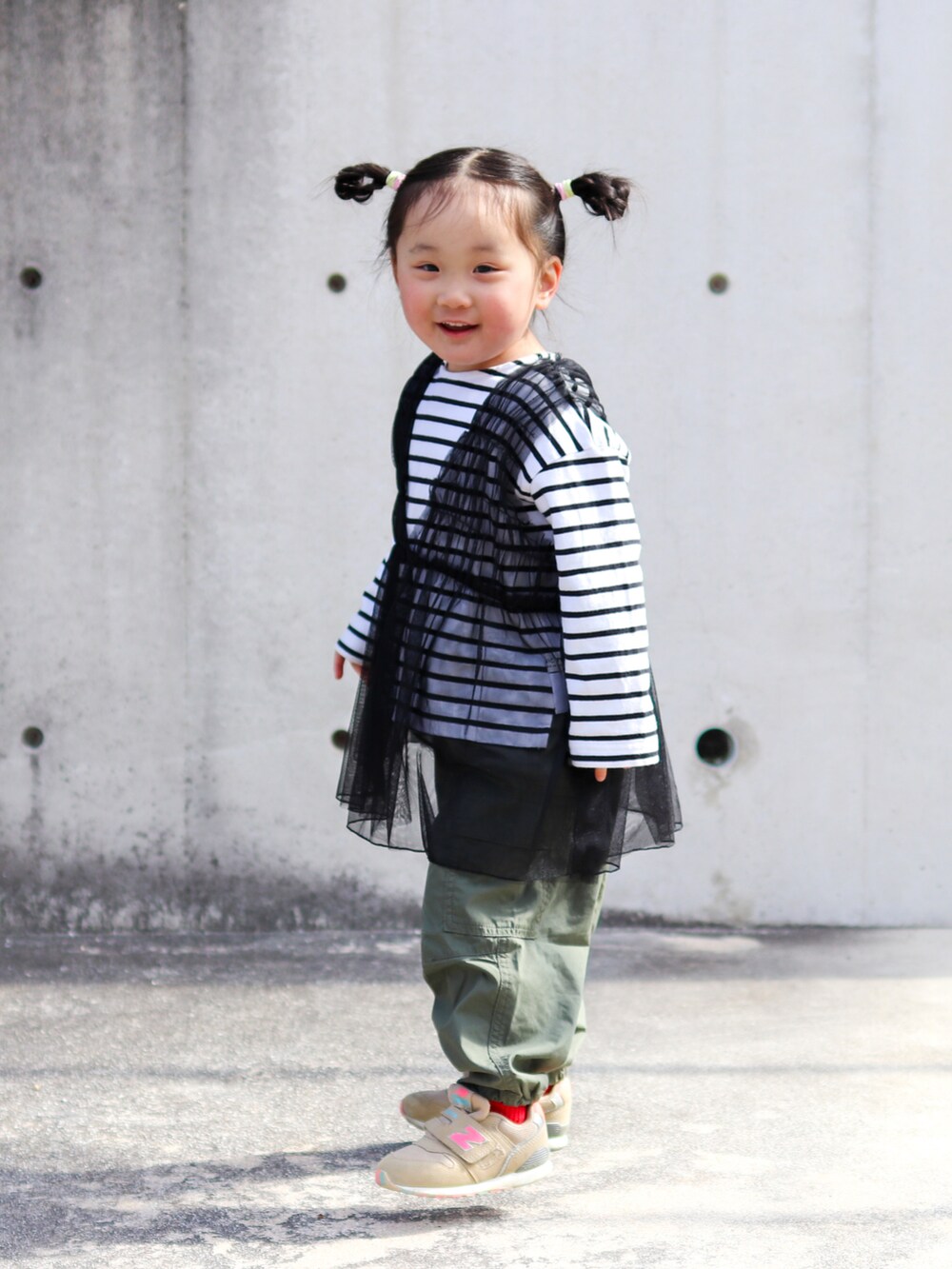 ブラック系のTシャツ/カットソー、ブラック系のチュニック、グリーン系のカーゴパンツを着用したキッズの春コーディネートの2枚目の写真