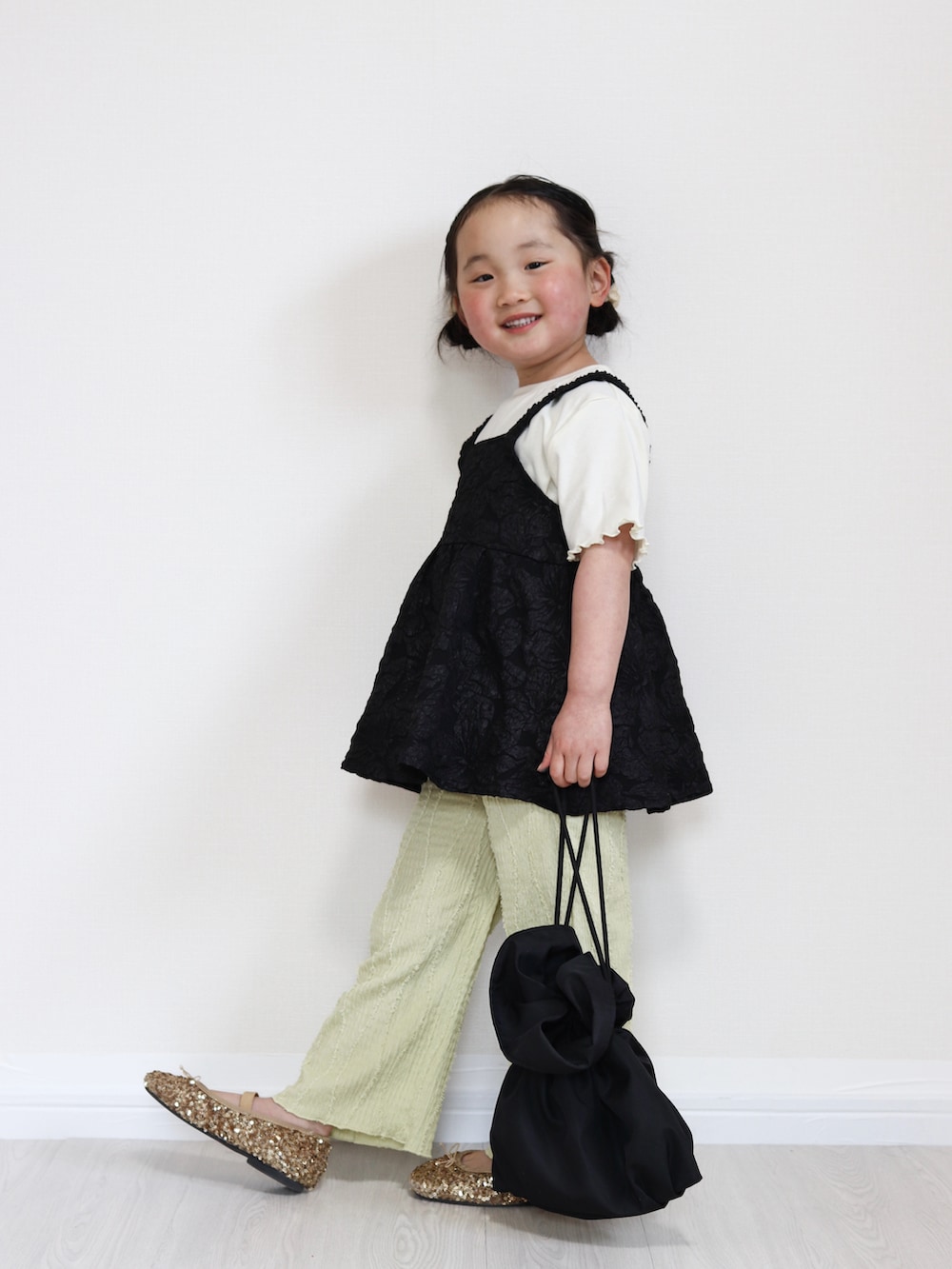 ブラック系のTシャツ/カットソー、グリーン系のその他パンツ、ブラック系のショルダーバッグを着用したキッズの春コーディネートの2枚目の写真