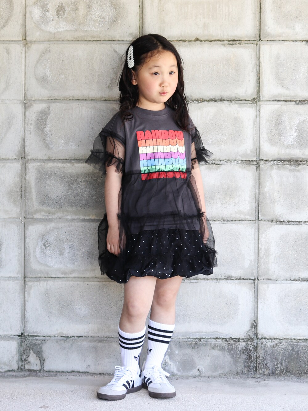 グレー系のTシャツ/カットソー、ブラック系のスカート、ホワイト系のスニーカーを着用したキッズの夏コーディネートの2枚目の写真