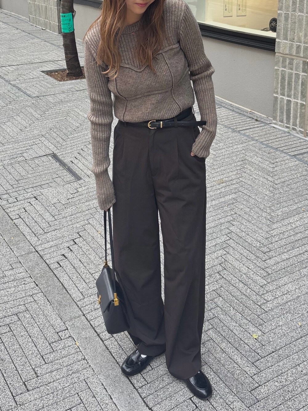 ブラウン系のニット/セーターを着用したレディースの秋コーディネートの2枚目の写真