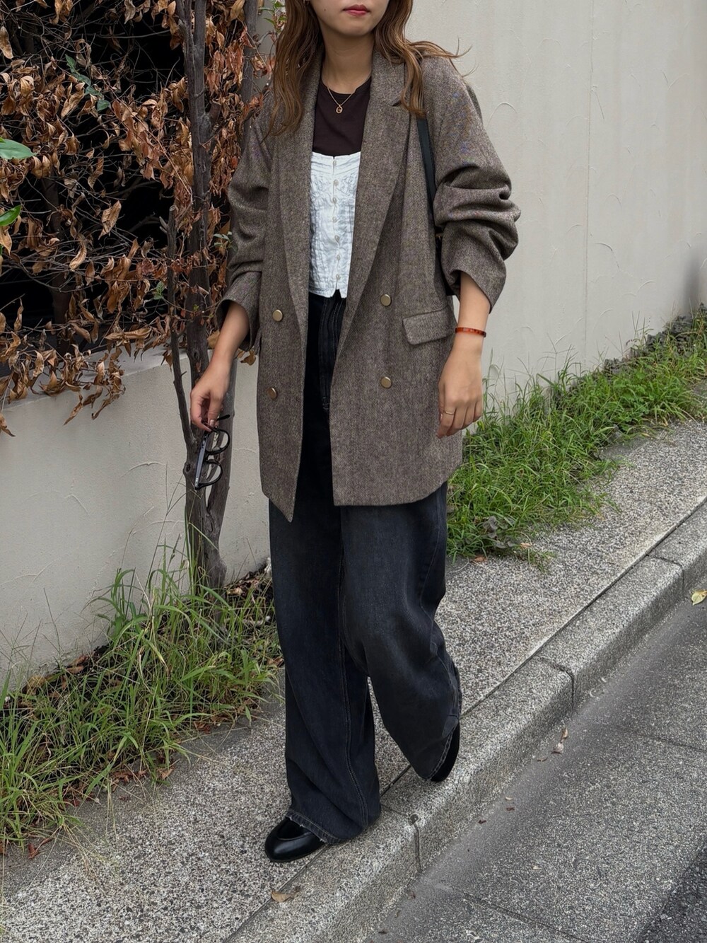 ブラウン系のテーラードジャケットを着用したレディースの秋コーディネートの2枚目の写真