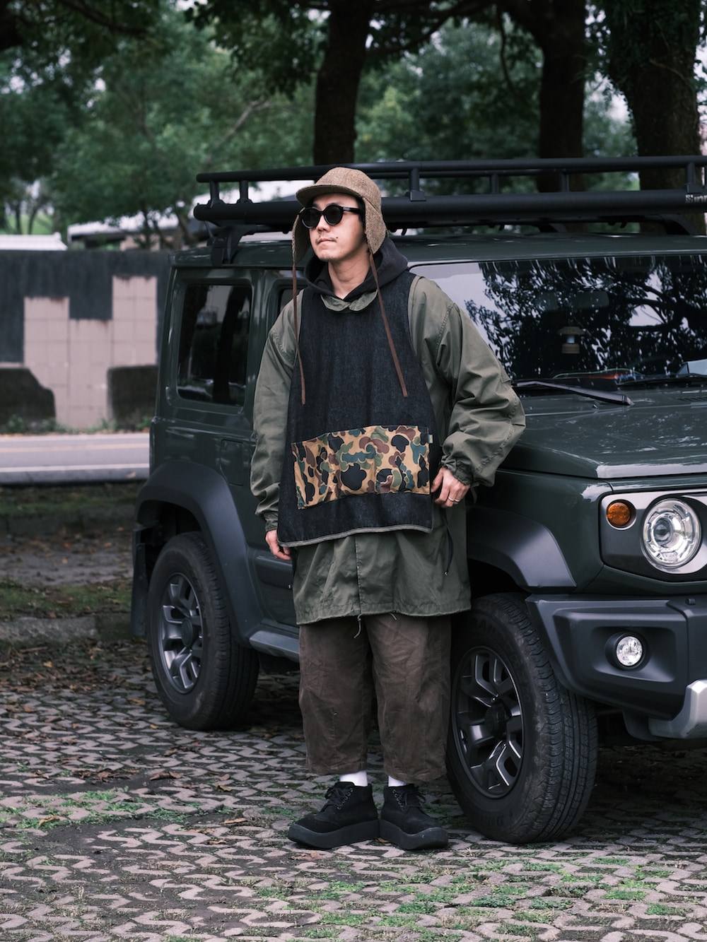 ブラック系のトップス、グリーン系のミリタリージャケット、ブラウン系のパンツを着用したメンズの冬コーディネートの2枚目の写真