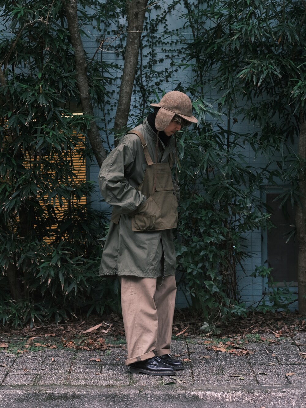 グリーン系のミリタリージャケット、ベージュ系のパンツ、ブラック系のブーツを着用したメンズの冬コーディネートの2枚目の写真