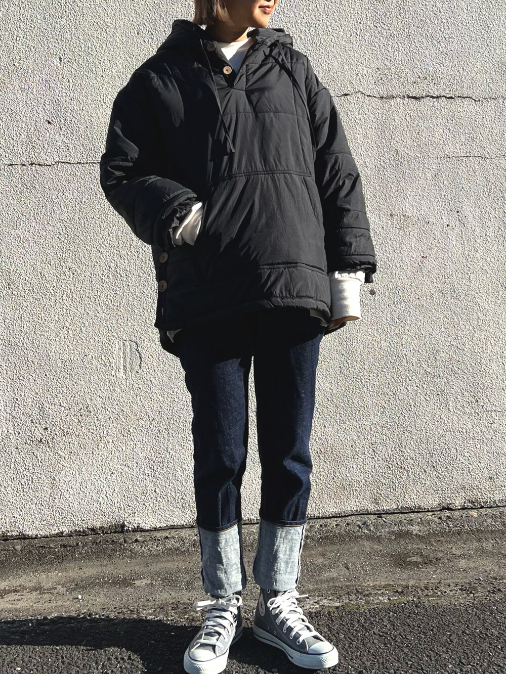 ブルー系のデニムパンツ、ブラック系のダウンジャケット/コートを着用したレディースの冬コーディネートの2枚目の写真