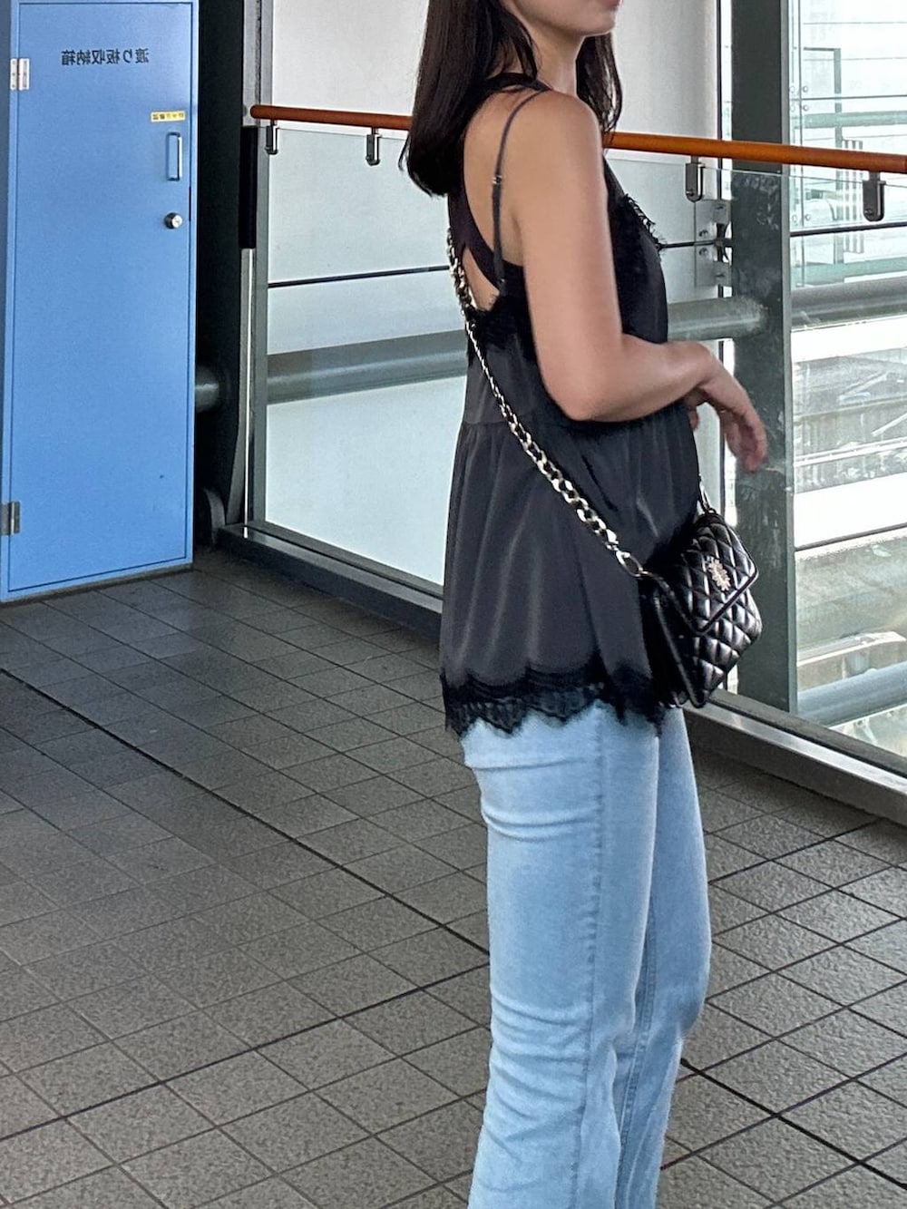 ブルー系のデニムパンツ、ブラック系のサンダルを着用したレディースの秋コーディネートの3枚目の写真