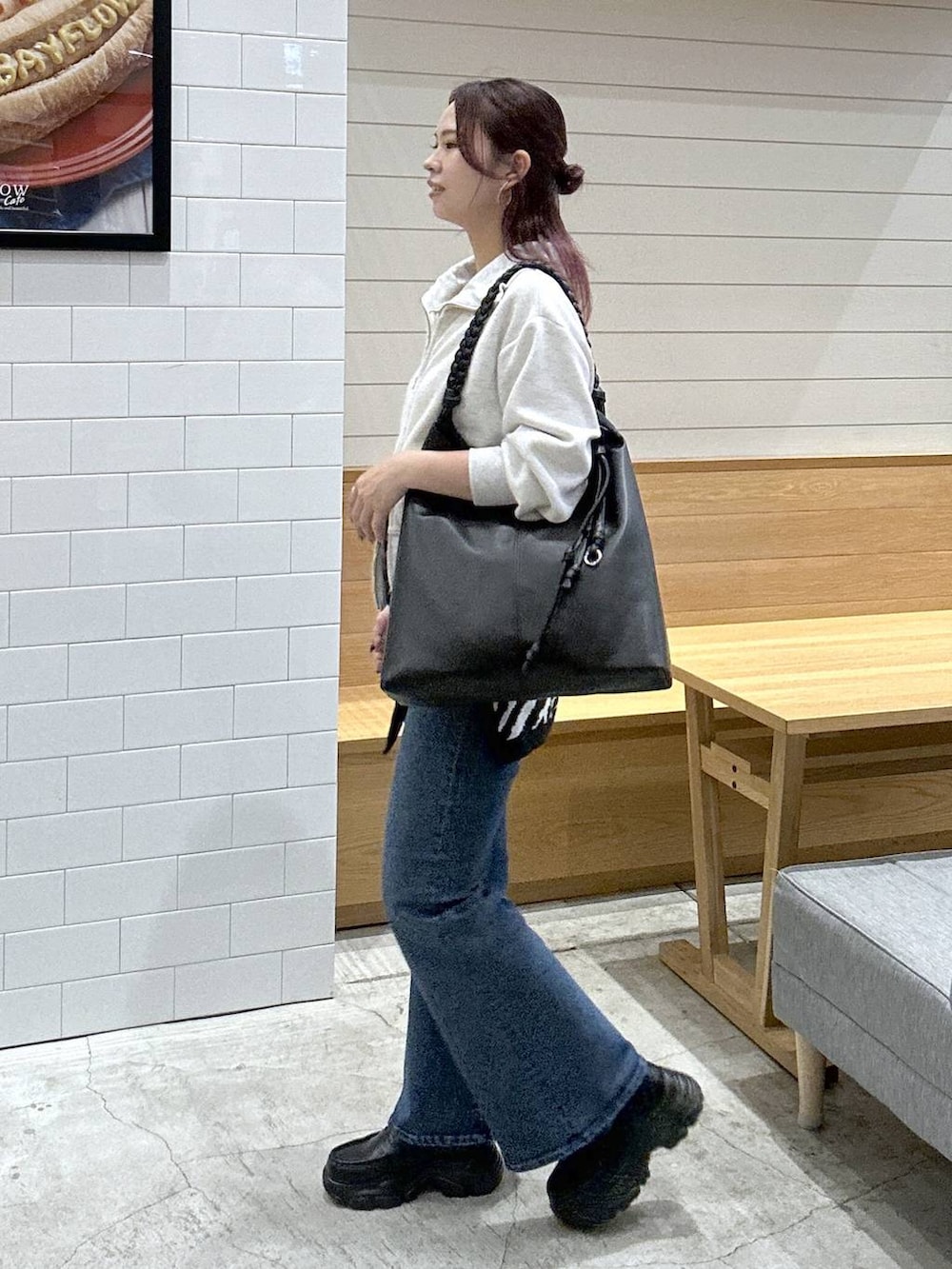 ブルー系のデニムパンツ、ブラック系のローファー、ブラック系のトートバッグを着用したレディースの秋コーディネートの2枚目の写真