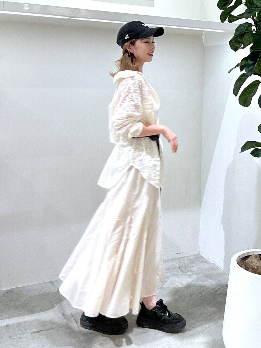 ブラック系のスニーカー、ホワイト系のシャツ/ブラウス、ブラック系のショルダーバッグを着用したレディースの春コーディネートの2枚目の写真