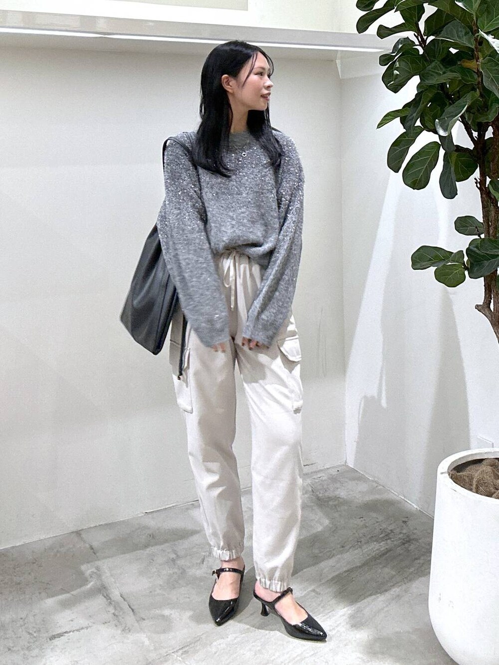 ブラック系のパンプス、ベージュ系のカーゴパンツ、グレー系のニット/セーターを着用したレディースの冬コーディネートの2枚目の写真