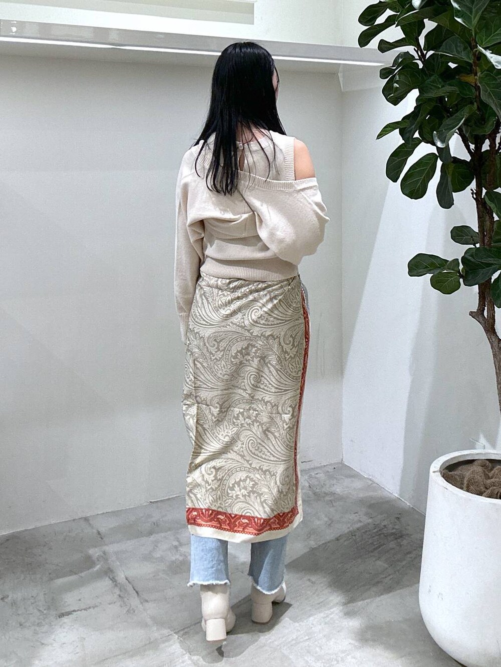 ブルー系のデニムパンツ、ベージュ系のブーツ、ホワイト系のニット/セーターを着用したレディースの冬コーディネートの4枚目の写真