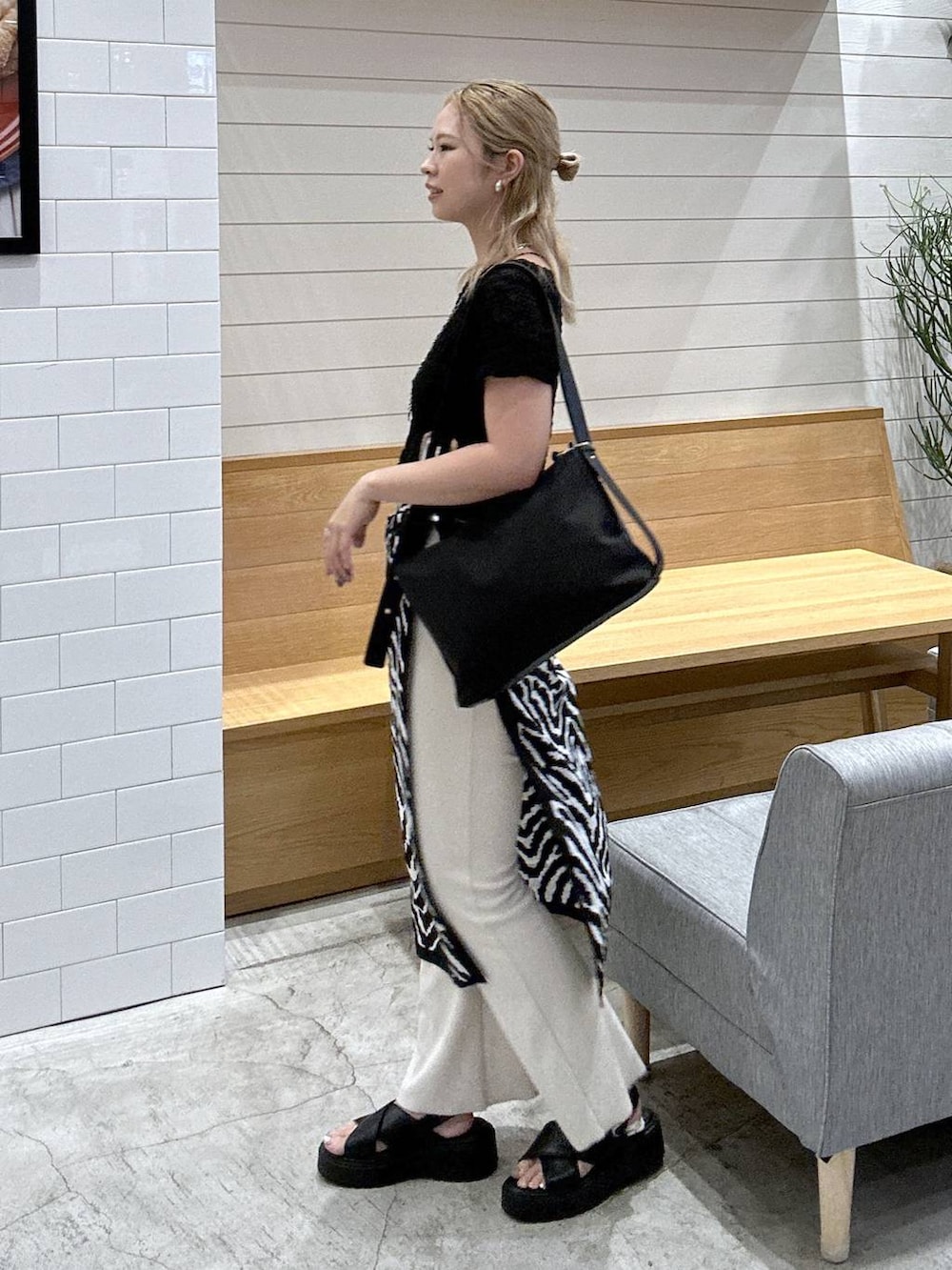 ベージュ系のその他パンツ、ブラック系のサンダル、ブラック系のTシャツ/カットソーを着用したレディースの秋コーディネートの2枚目の写真