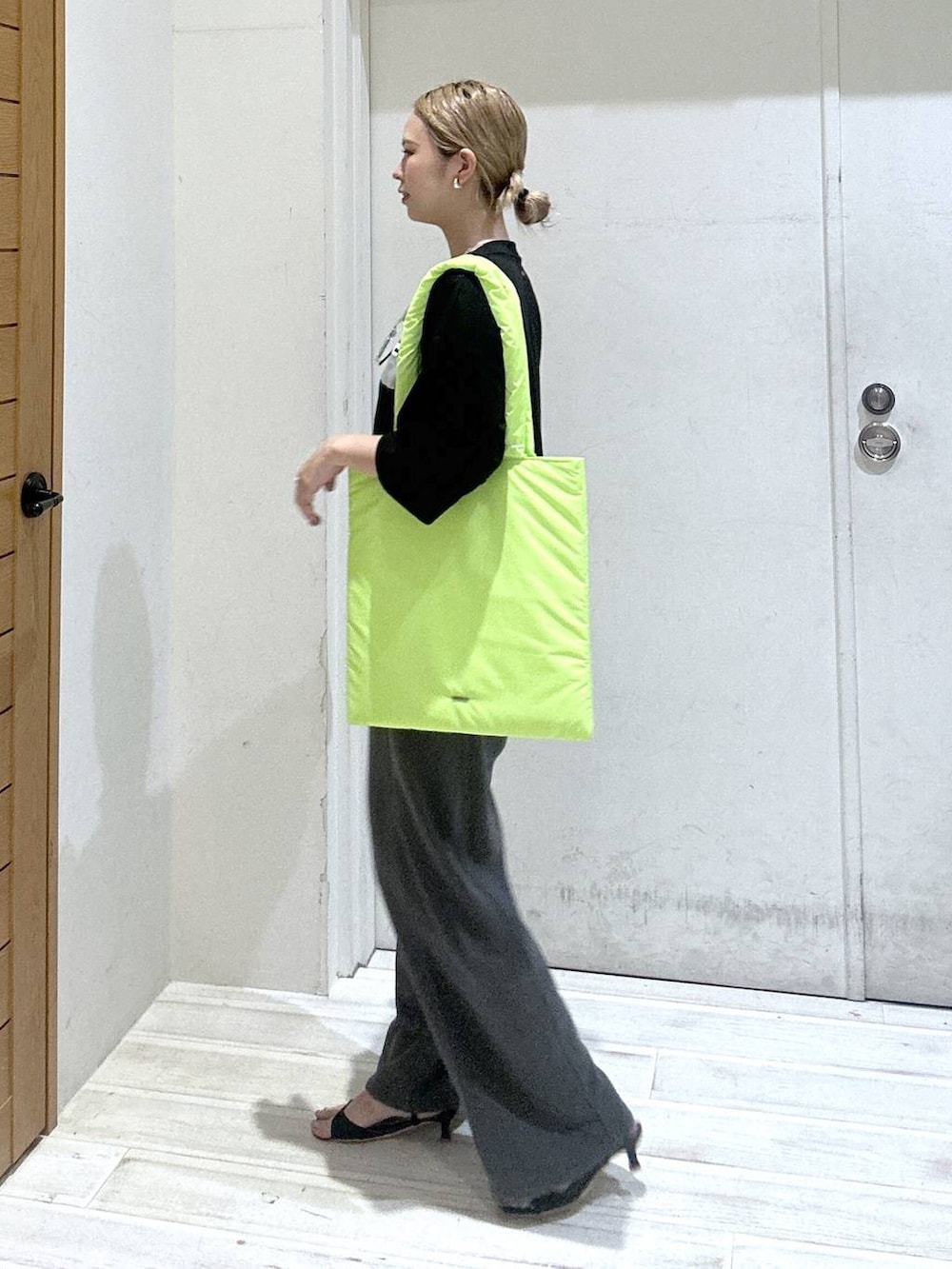 グレー系のスウェットパンツ、イエロー系のトートバッグ、ブラック系のTシャツ/カットソーを着用したレディースの秋コーディネートの2枚目の写真