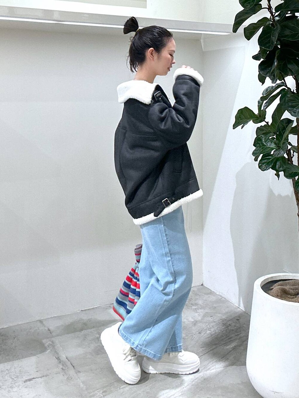 ホワイト系のスニーカー、ホワイト系のTシャツ/カットソー、ブラック系のムートンコートを着用したレディースの冬コーディネートの3枚目の写真