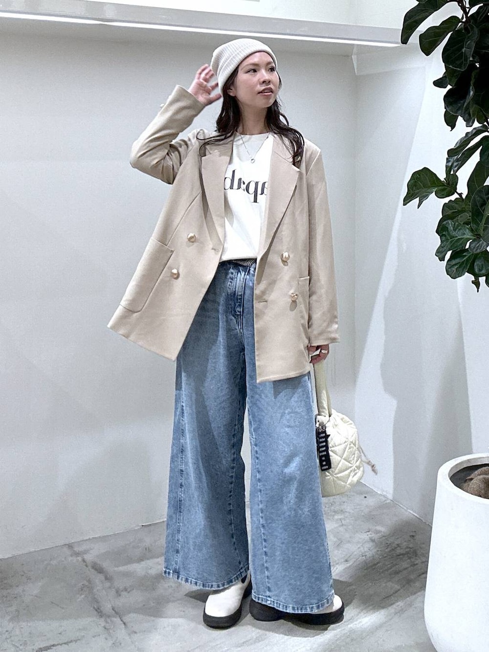 ホワイト系のスウェット、ホワイト系のブーツ、ベージュ系のテーラードジャケットを着用したレディースの冬コーディネートの3枚目の写真