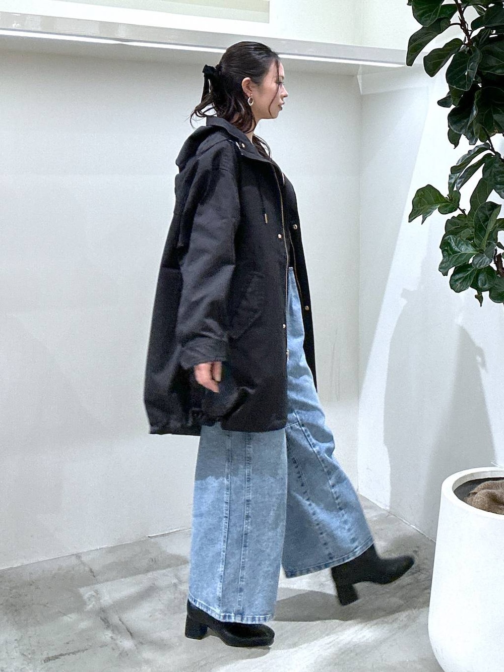 ブラック系のブーツ、ブラック系のハンドバッグ、ブラック系のマウンテンパーカーを着用したレディースの冬コーディネートの2枚目の写真