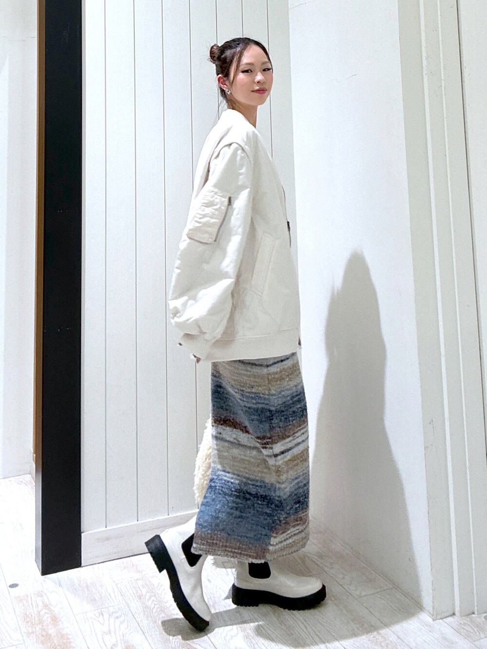 ブラック系のTシャツ/カットソー、ホワイト系のMA-1、ブルー系のスカートを着用したレディースの秋コーディネートの3枚目の写真