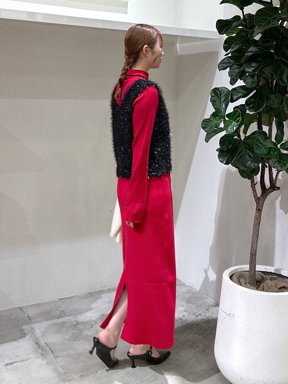 シルバー系のショルダーバッグ、ブラック系のパンプス、レッド系のニット/セーターを着用したレディースの秋コーディネートの3枚目の写真