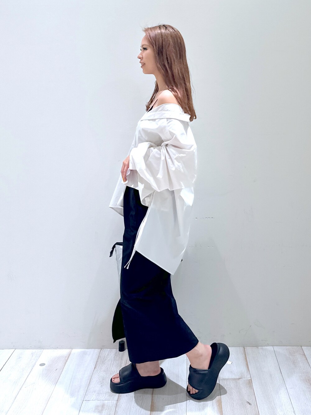 シルバー系のトートバッグ、ホワイト系のシャツ/ブラウス、ブラック系のスカートを着用したレディースの夏コーディネートの2枚目の写真