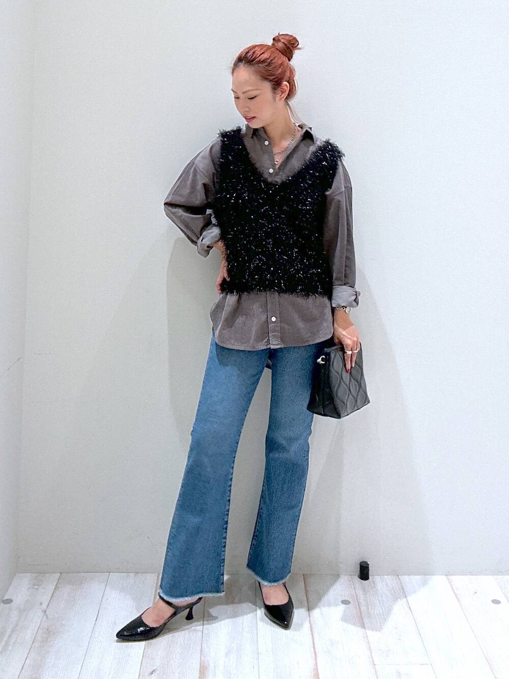 ブラック系のショルダーバッグ、ブルー系のデニムパンツ、グレー系のシャツ/ブラウスを着用したレディースの秋コーディネートの2枚目の写真