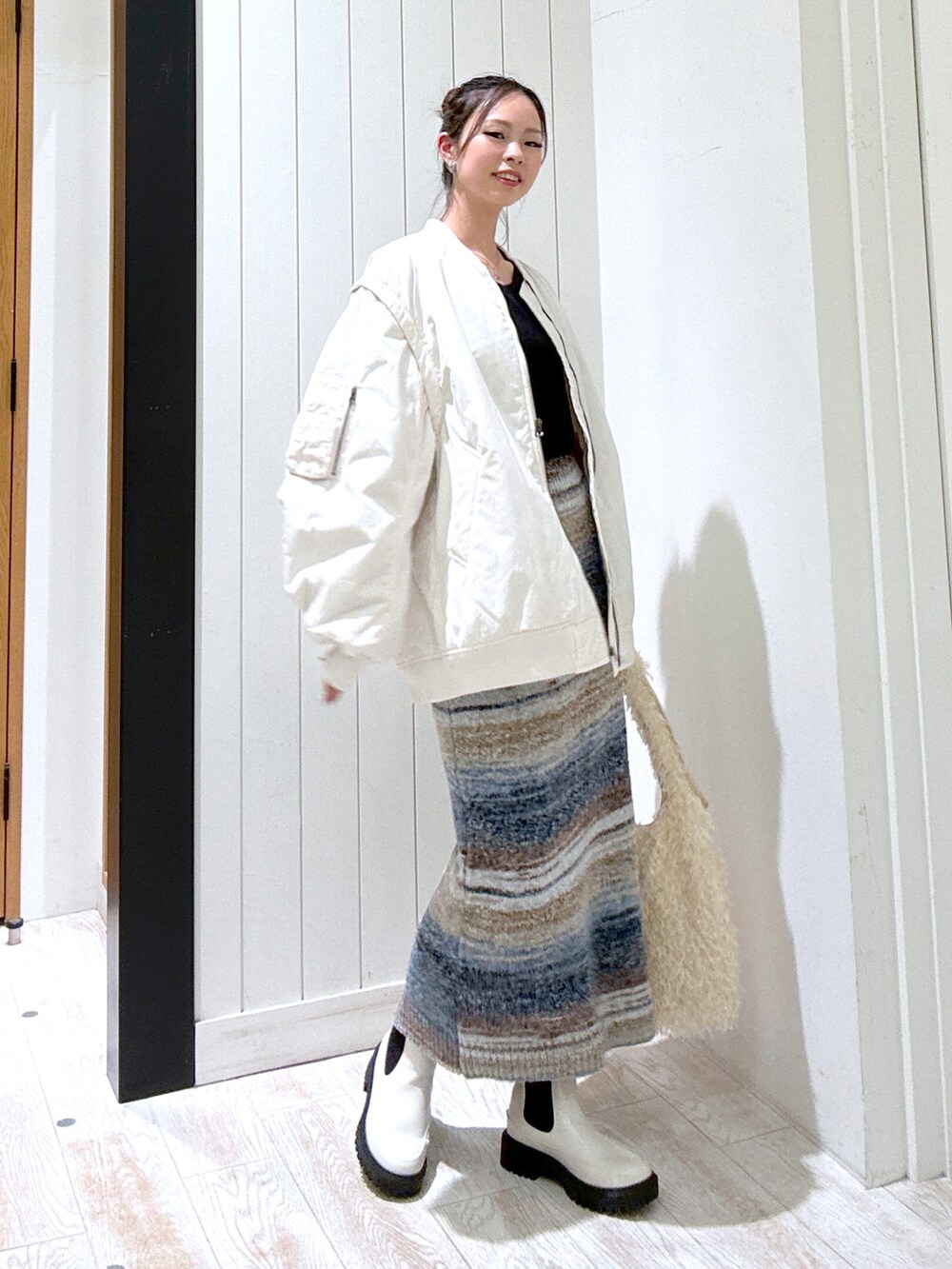 ブラック系のTシャツ/カットソー、ホワイト系のMA-1、ブルー系のスカートを着用したレディースの秋コーディネートの2枚目の写真