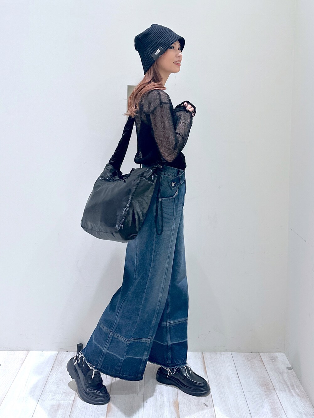 ブルー系のデニムパンツ、ブラック系のローファー、ブラック系のショルダーバッグを着用したレディースの春コーディネートの3枚目の写真