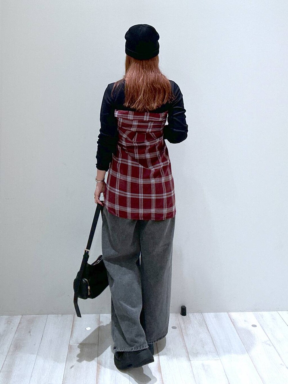 グレー系のデニムパンツ、レッド系のシャツ/ブラウス、ブラック系のブーツを着用したレディースの秋コーディネートの3枚目の写真