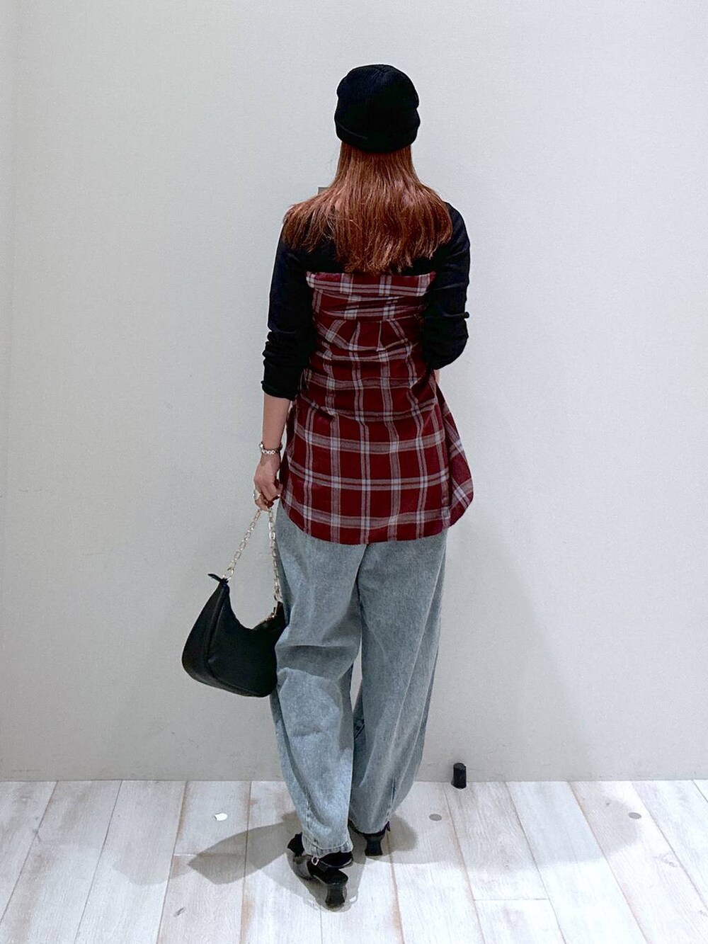 レッド系のシャツ/ブラウス、ブラック系のパンプス、ブルー系のデニムパンツを着用したレディースの秋コーディネートの3枚目の写真