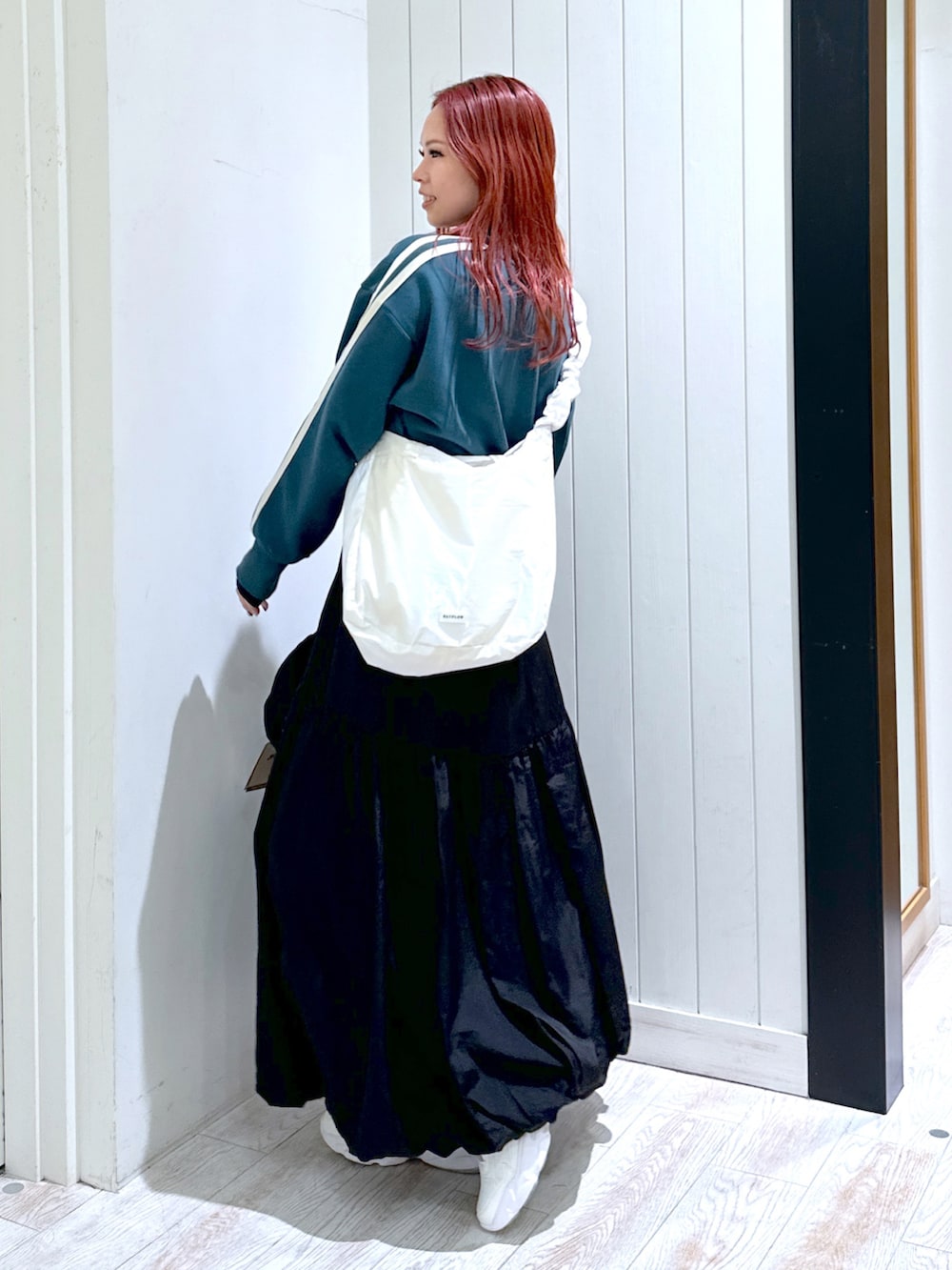 ブラック系のスカート、グリーン系のスウェット、ホワイト系のショルダーバッグを着用したレディースの春コーディネートの5枚目の写真