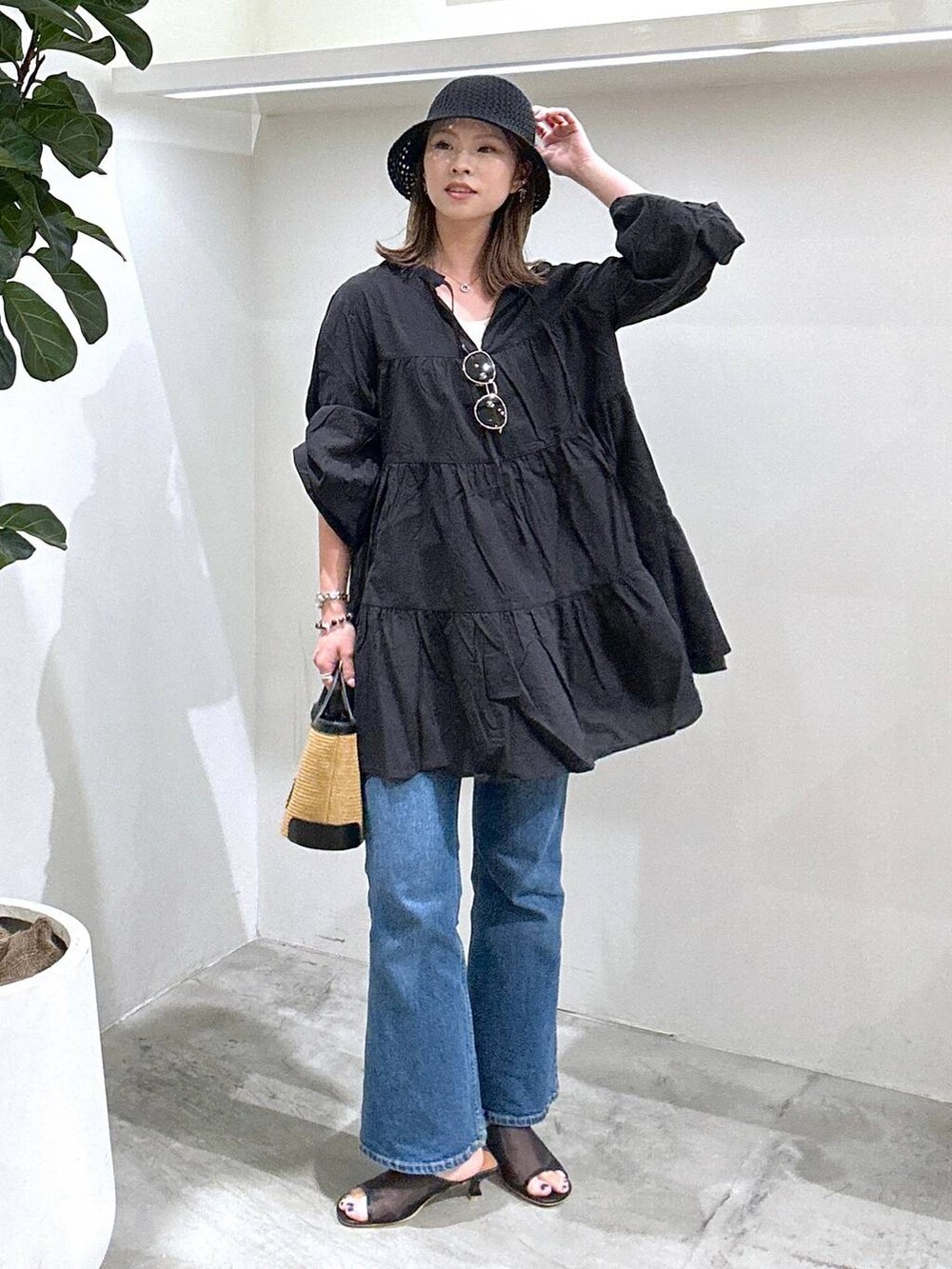 ブラック系のサンダル、ブルー系のデニムパンツ、ブラック系のショルダーバッグを着用したレディースの春コーディネートの2枚目の写真