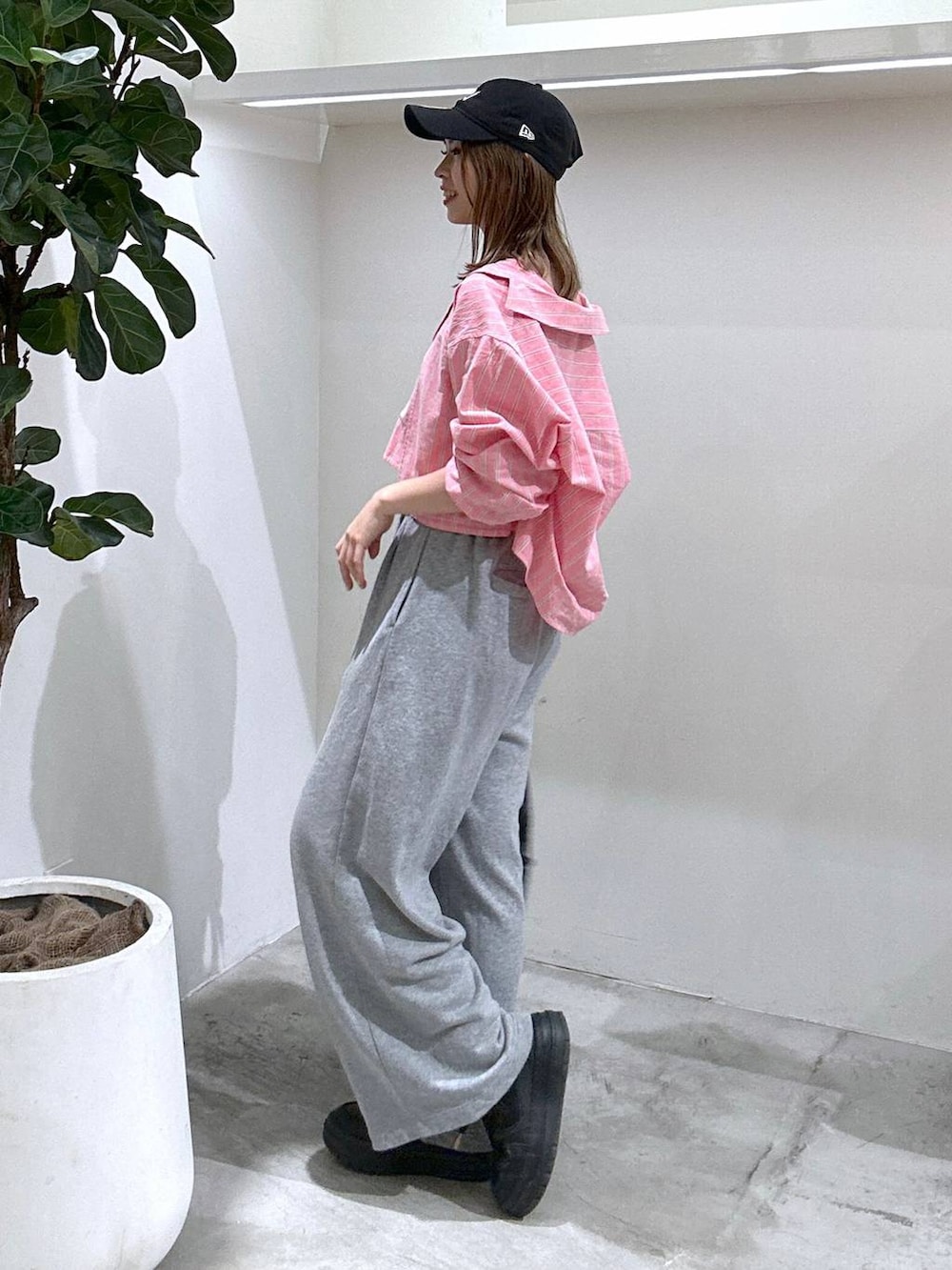 ブラック系のスニーカー、ブラック系のバックパック/リュック、グレー系のスウェットパンツを着用したレディースの春コーディネートの3枚目の写真