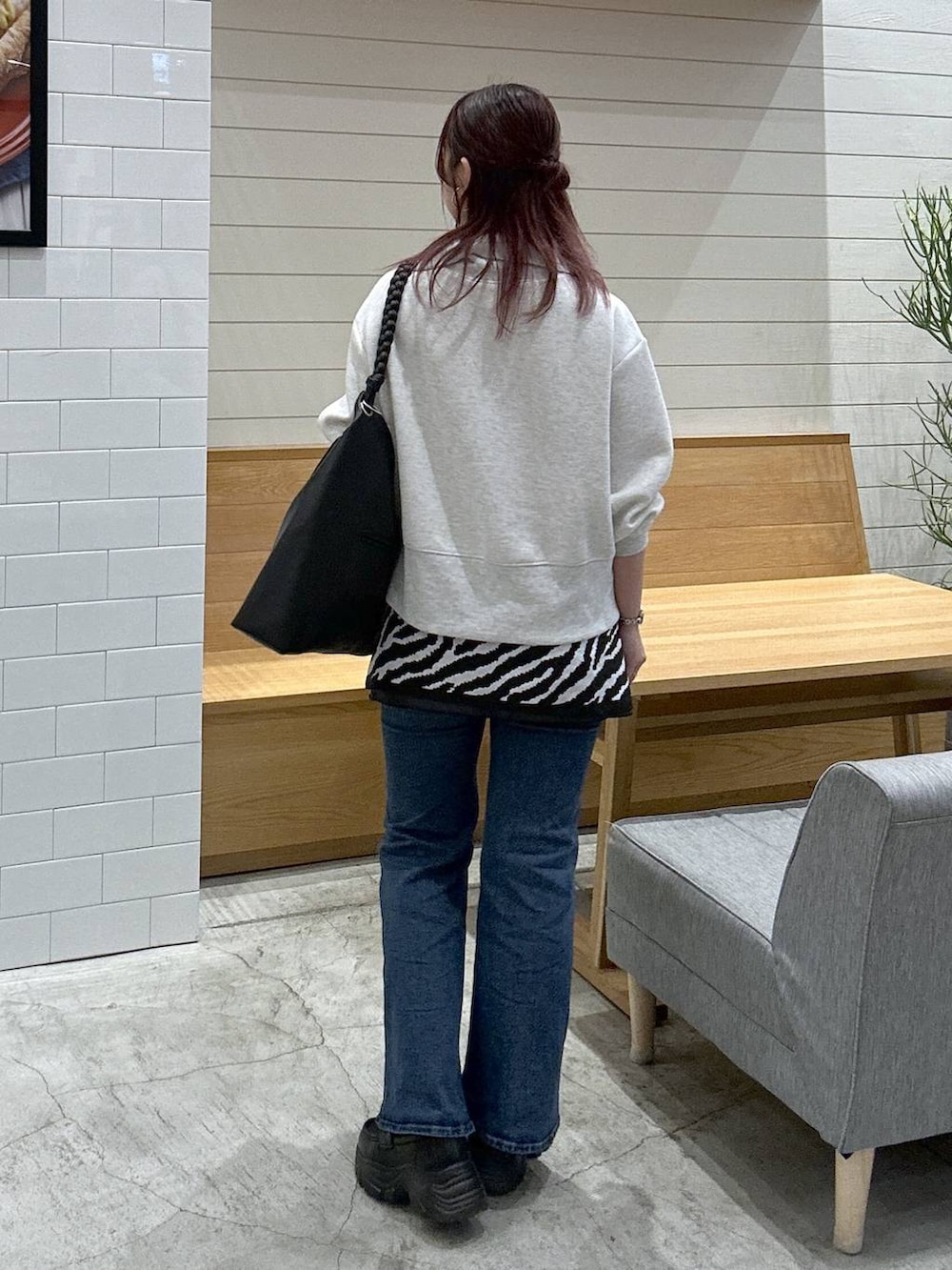ブルー系のデニムパンツ、ブラック系のローファー、ブラック系のトートバッグを着用したレディースの秋コーディネートの3枚目の写真