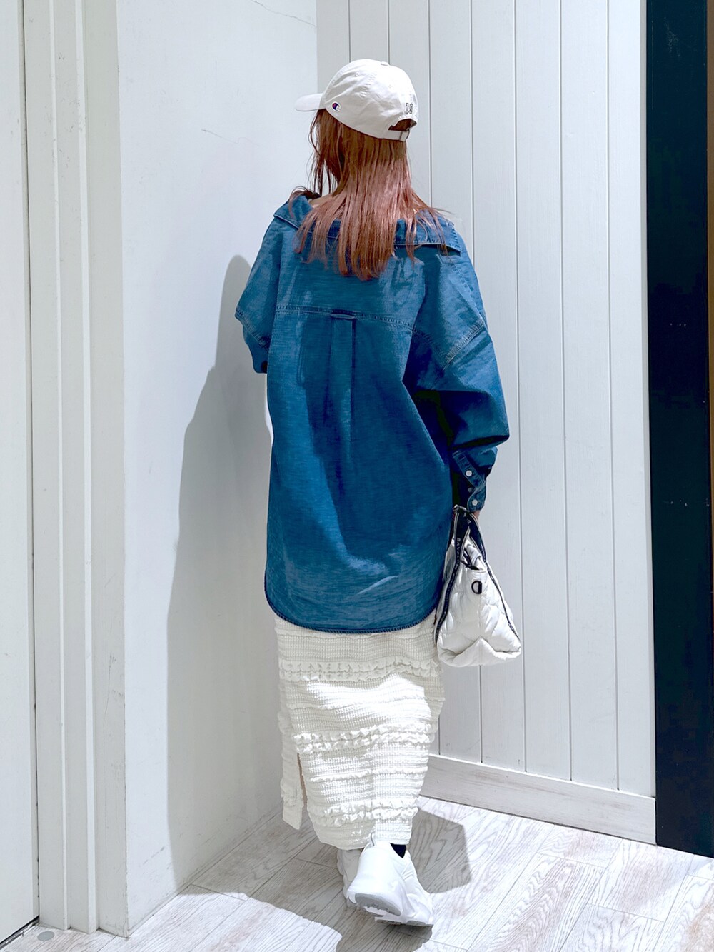 ホワイト系のスニーカー、ホワイト系のスカート、ホワイト系のトートバッグを着用したレディースの春コーディネートの3枚目の写真