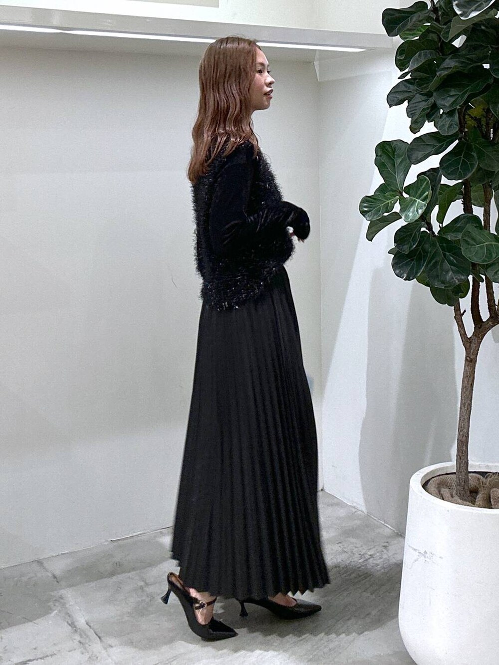 ブルー系のショルダーバッグ、ブラック系のスカート、ブラック系のパンプスを着用したレディースの秋コーディネートの2枚目の写真